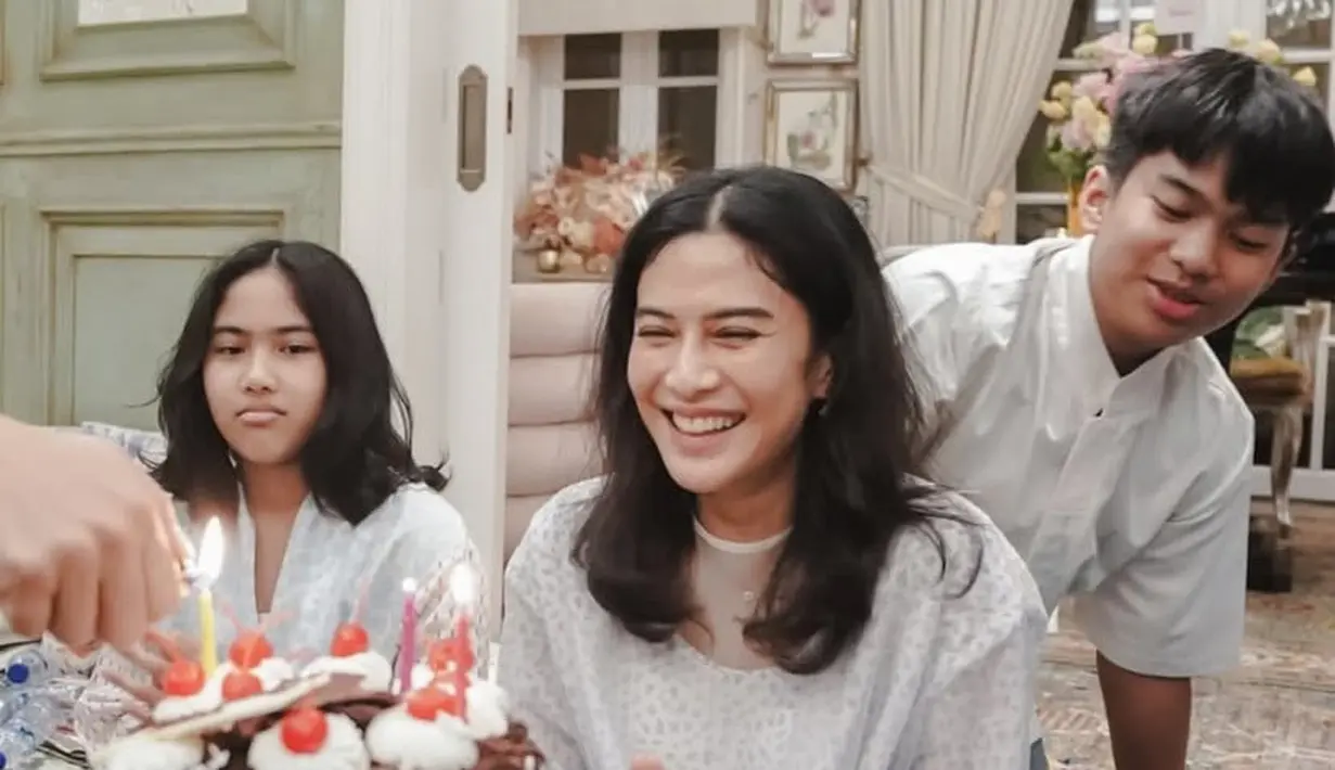 Dian memilih mengenakan tunik lengan 3/4 warna dasar putih dengan corak biru. Dipadukan celana panjang putih. [@therealdisastr]