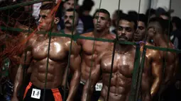 Kontestan Palestina menunggu untuk tampil dalam kompetisi binaraga lokal di Gaza, 26 Oktober 2018. Mereka memamerkan keindahan tubuh berotot di hadapan para juri kontes yang diselenggarakan oleh Federasi Binaraga dan Kebugaran Palestina. (AP/Khalil Hamra)