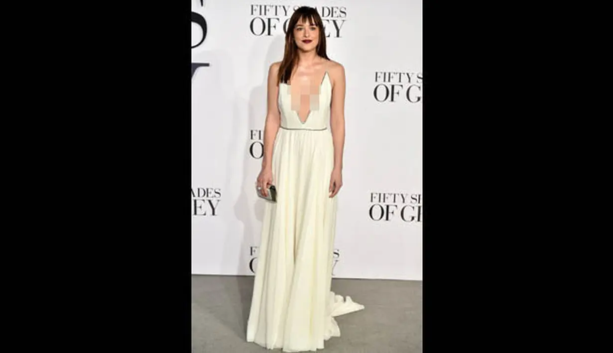 Mengenakan gaun putih dengan potongan dada yang rendah, Dakota Johnson terlihat seksi saat menghadiri premiere film Fifty Shades of Grey di London, Kamis (12/2/2015). (AFP PHOTO/LEON NEAL)