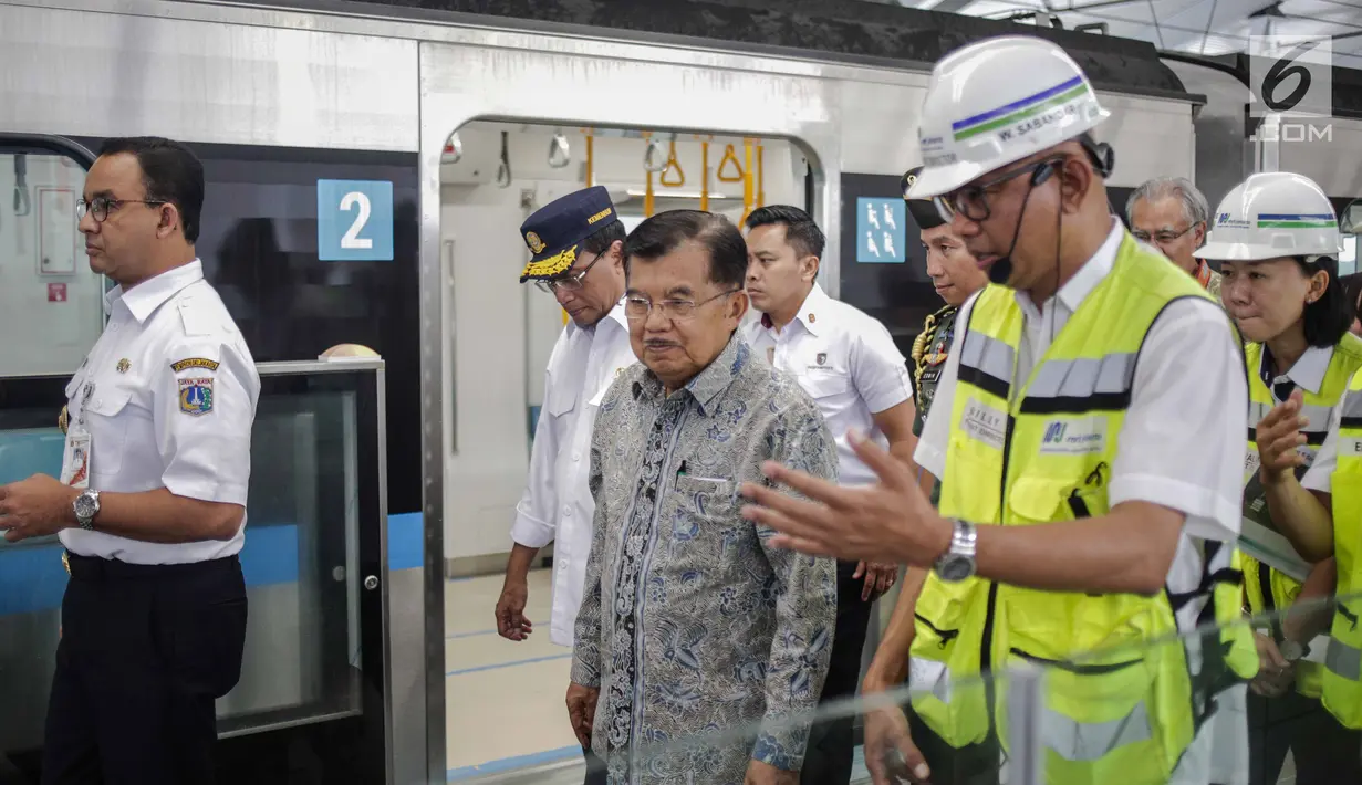 Wakil Presiden Jusuf Kalla mendengarkan penjelasan Dirut MRT William Sabandar saat meninjau pengoperasian MRT  dari Stasiun Bundaran HI, Jakarta, Rabu (20/2). Jusuf Kalla meninjau sekaligus menjajal rangkaian kereta MRT. (Liputan6.com/Faizal Fanani)