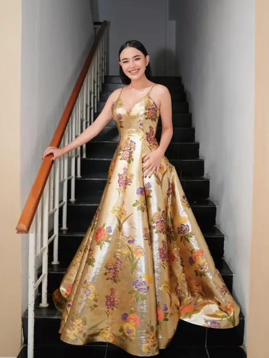 Amanda juga tampil bak princess mengenakan gaun spaghetti strap keemasan dengan gambar bunga yang mewah dari Adeline Esther. [@adelinesther.co]