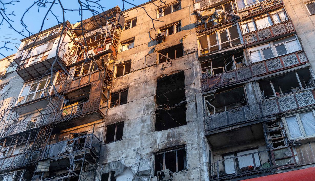 Puing-puing drone menyebabkan kerusakan signifikan pada bagian depan berikut jendela beberapa gedung apartemen bertingkat tinggi di kota Odesa. Tampak foto yang menunjukkan bangunan tempat tinggal yang rusak akibat serangan di Odesa, pada 31 Desember 2025, di tengah invasi Rusia di Ukraina. (Oleksandr GIMANOV/AFP)