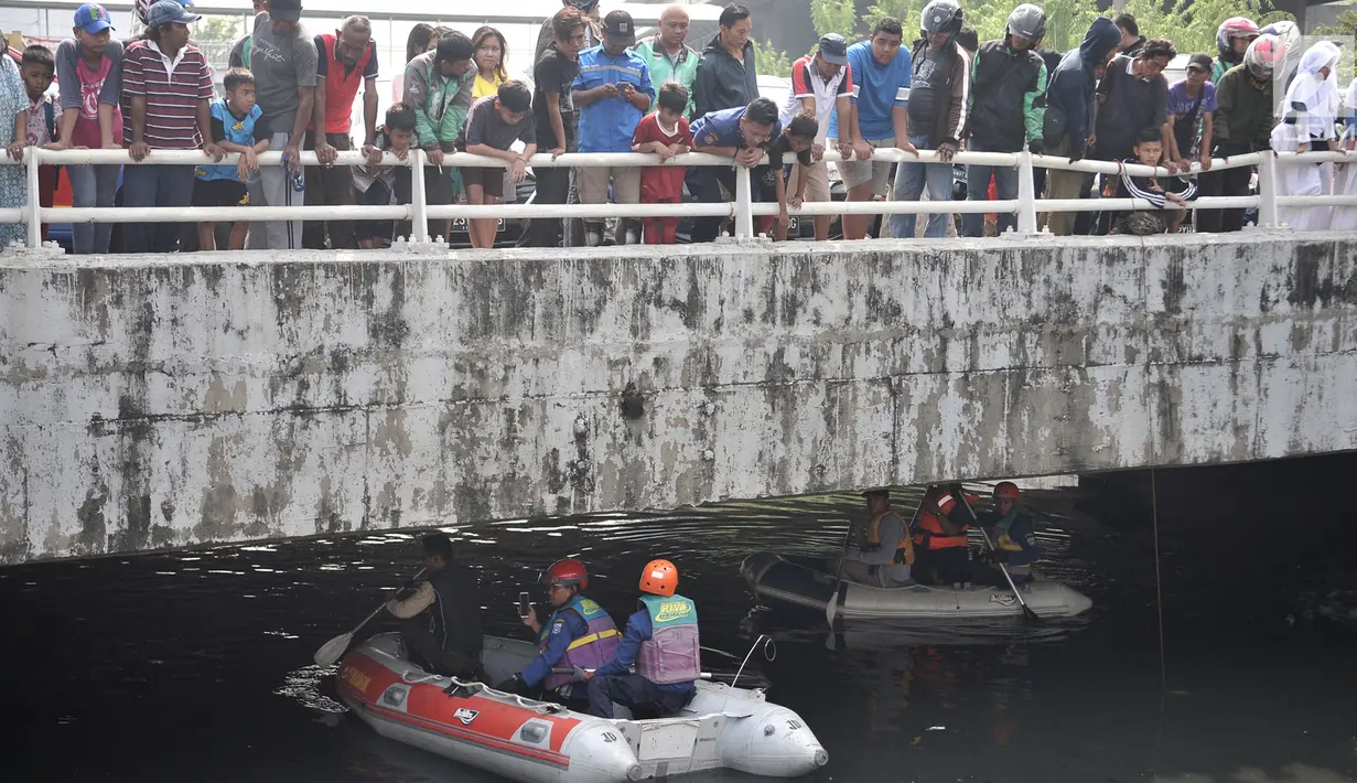 Warga berkerumun melihat upaya tim gabungan Damkar, BPBD, dan KLHK melakukan pencarian buaya di Kali Grogol, Jakarta Barat, Kamis (28/6). Satwa yang tergolong buas tersebut dikhawatirkan mengancam keselamatan. (Merdeka.com/Iqbal S. Nugroho)