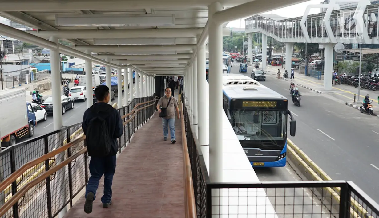 Warga melintasi jembatan penyeberangan (Skybridge) yang menghubungkan Stasiun LRT Velodrome dengan Halte Transjakarta Pemuda di Rawamangun, Jakarta, Senin (29/7/2019). Skybridge berdesain artistik tersebut memiliki panjang sekitar 500 meter dan lebar 2 meter. (Liputan6.com/Immanuel Antonius)