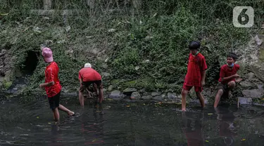 Sejumlah anak-anak mencari belut di anak kali menteng, Jakarta, Selasa (8/6/2021). Ruang bermain anak-anak di Jakarta kian terbatas. Terbatas lahan bermain membuat anak-anak Jakarta bermain ditempat yang tak semestinya demi mencari kesenangan. (Liputan6.com/Faizal Fanani)