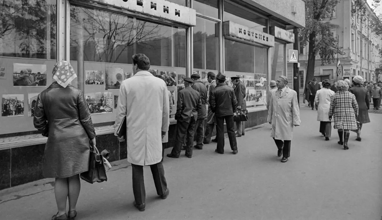 Orang-orang berkumpul untuk membaca berita di depan etalase toko pada masa Uni Soviet di Jalan Khreshchatyk, Kiev, 18 Oktober 1975. (Pierre GUILLAUD/AFP)