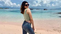 Penampilan Agatha Valerie saat liburan memang tampak begitu santai. Kali ini ketika menikmati pantai di Labuan Bajo, ia terlihat mengenakan tank top yang dipadukan dengan celana jeans. Kacamata yang ia pakai pun membuatnya penampilannya makin stylish.(Liputan6.com/IG/@agathavalerie)