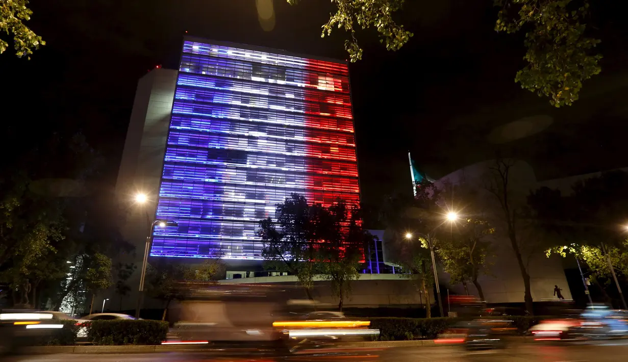 Gedung senat Meksiko memancarkan lampu dengan warna bendera Prancis yaitu warna biru, putih dan merah di kota meksiko, (14/11). Aksi ini sebagai ungkapan belasungkawa menyusul serangan teror di Perancis. (REUTERS/Tomas Bravo)