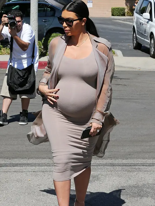 Selain sepatu hak tingginya yang mencuri perhatian, penampilan Kim dalam balutan baju warna senada dengan kulit tersebut menonjolkan sisi glamor Kim. (via dailymail.co.uk)