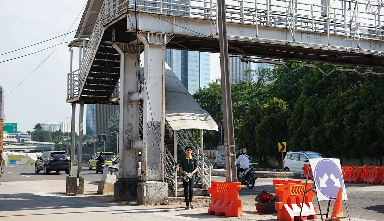 Pejalan kaki melintas di dekat tangga akses JPO di Jalan Antasari, Jakarta, Jumat (24/5/2019). Proyek pelebaran jalan yang tidak dibarengi dengan pemanjangan JPO menyebabkan akses tangga JPO tersebut berada di tengah jalan. (Liputan6.com/Immanuel Antonius)