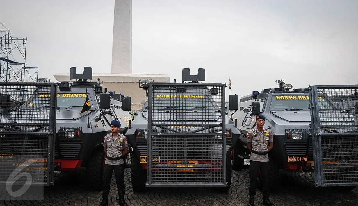 Anggota polisi berdiri didekat deretan kendaraan taktis (rantis) jelang apel gelar pasukan ops Mantap Praja Jaya dalam rangka PAM Pilkada Serentak Tahun 2017 di Lapangan Monas, Jakarta, Rabu (12/10). (Liputan6.com/Faizal Fanani)