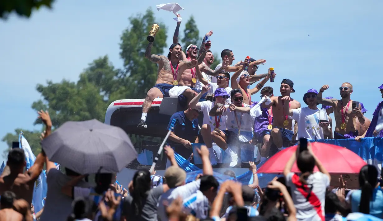 Pemain Argentina Leandro Paredes memamerkan trofi Piala Dunia 2022 saat parade kemenangan di Buenos Aires, Argentina, 20 Desember 2022. Jutaan orang menyambut kepulangan Lionel Messi dan kawan-kawan bak pahlawan usai Argentina menjuarai Piala Dunia 2022. (AP Photo/Natacha Pisarenko)