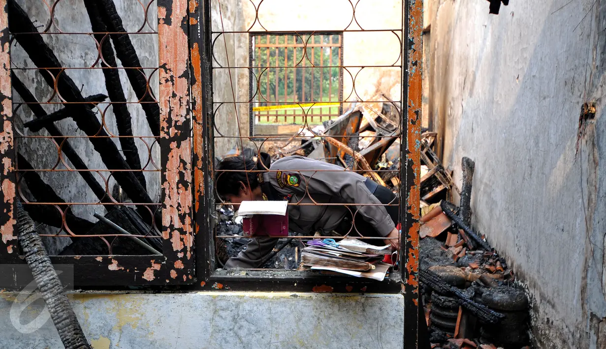 Seorang petugas kepolisian saat memeriksa salah satu ruangan Kantor Komisi Nasional Perlindungan Anak pasca terbakar, Jakarta, Senin (29/6/2015). Kantor Komnas PA terbakar pada Sabtu, 28 Juni 2015 sekitar pukul 21.00 WIB. (Liputan6.com/Yoppy Renato)
