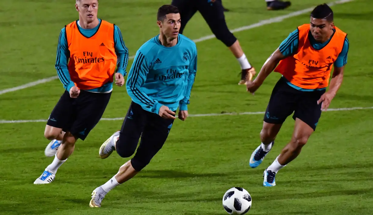 Bintang Real Madrid, Cristiano Ronaldo, menggiring bola saat latihan di Stadion NY University Abu Dhabi, UAE, Senin (11/12/2017). Los Blancos bersiap jelang semifinal FIFA Club World Cup. (AFP/Giuseppe Cacace)