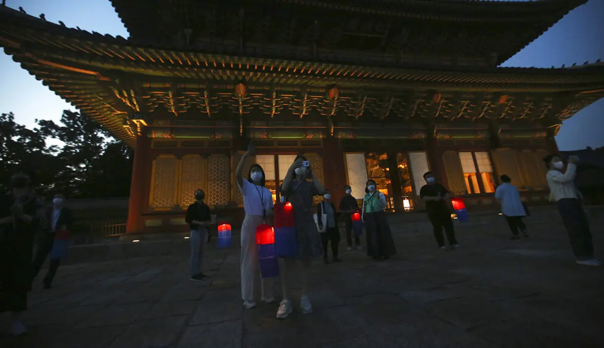 Pengunjung yang memegang lentera tradisional Korea berfoto selama Tur Cahaya Bulan di tengah pandemi virus corona COVID-19 di Istana Changdeokgung, Seoul, Korea Selatan, Kamis (13/5/2021). Istana Changdeok adalah istana Dinasti Joseon. (AP Photo/Ahn Young-joon)