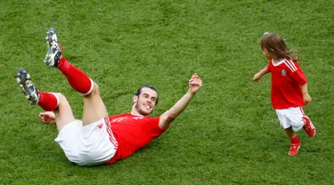 Penyerang Wales, Gareth Bale meluangkan waktu bersama putrinya, Alba seusai memenangkan laga atas Irlandia Utara dalam babak 16 besar Euro 2016 di Parc des Princes, Paris, Prancis, Minggu (26/6). (REUTERS/ Christian Hartmann)