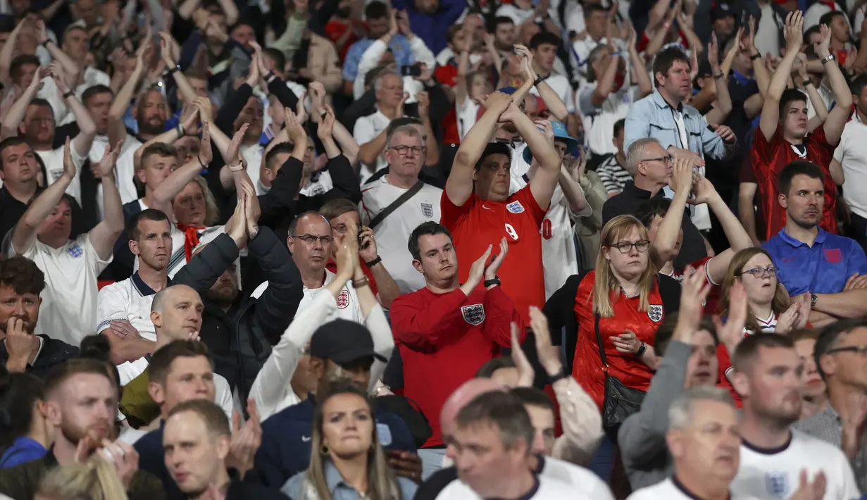 Suporter Inggris bertepuk tangan untuk timnya setelah kalah dari Italia pada pertandingan final Euro 2020 di Stadion Wembley, London, Minggu (11/7/2021). Italia mengalahkan Inggris 3-2 dalam adu penalti setelah pertandingan berakhir dengan skor 1-1. (Carl Recine/Pool Photo via AP)