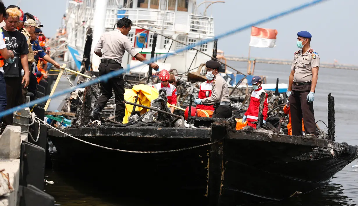 Tim SAR gabungan mengevakuasi jenazah dari atas kapal Zahro Express yang terbakar, di Pelabuhan Muara Angke, Minggu (1/1). Kapal yang mengangkut lebih dari 200 penumpang itu terbakar saat dalam perjalanan menuju Pulau Tidung. (REUTERS/Darren Whiteside)