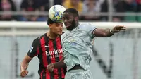 Pemain AC Milan Koni De Winter (kiri) dan pemain Udinese Keinan Davis melompat untuk berebut bola pada laga Serie A/Liga Italia antara AC Milan vs Udinese di Milan, Italia, Sabtu, 11 April 2026. (AP Photo/Antonio Calanni)