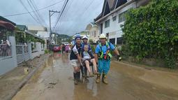 Tim penyelamat mengevakuasi seorang warga dari rumahnya yang terendam banjir menyusul hujan deras yang dibawa oleh Topan Kalmaegi di sebuah permukiman di Kota Cebu, Filipina tengah, pada Selasa 4 November 2025. Dengan hembusan angin berkecepatan hingga 150 kilometer per jam dan hembusan mencapai 205 kilometer per jam, Topan Kalmaegi meninggalkan jejak kehancuran di Kota Cebu, Filipina tengah. (Alan TANGCAWAN/AFP)