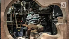 Soedarmadi (51) yang akrab disapa Bone menyelesaikan pembuatan gitar di workshop Bone's Costum Guitar, Jatinegara, Jakarta, Rabu (10/3/2021). Pandemi virus Corona menyebabkan usaha pembuatan dan servis gitar yang dirintis sejak 1989 itu nyaris tanpa pemasukan. (merdeka.com/Iqbal S Nugroho)