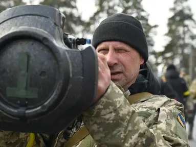 Anggota Pasukan Pertahanan Teritorial Ukraina memeriksa senjata anti-tank NLAW di tengah invasi Rusia yang sedang berlangsung ke Ukraina di Kiev (9/3/2022). (AFP/Genya Savilov)
