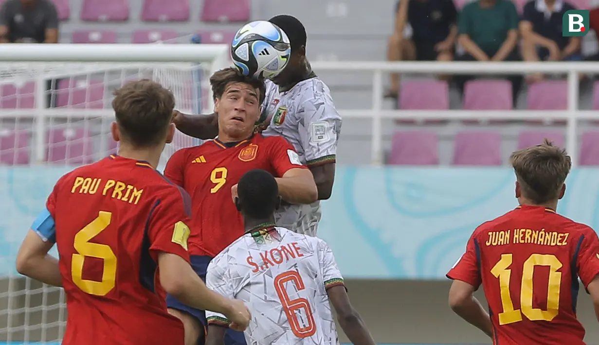 <p>Pemain Timnas Spanyol U-17, Marc Guiu (kiri) berduel dengan pemain Mali U-17 dalam pertandingan babak penyisihan Grup B Piala Dunia U-17 di Stadion Manahan, Solo, Senin (13/11/2023). (Bola.com/Arief Bagus)</p>