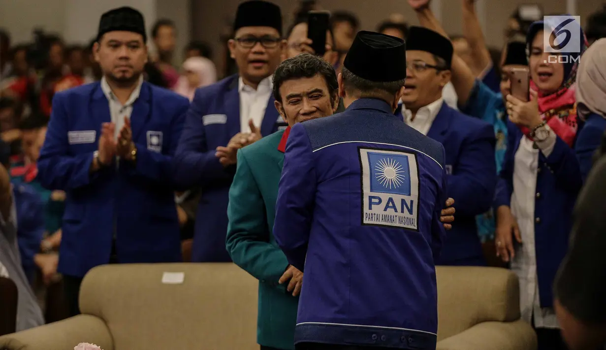 Ketua Umum Partai Amanat Nasional Zulkifli Hasan berpelukan dengan Ketua Umum Partai Idaman Rhoma Irama saat deklarasi bergabungnya Partai Idaman ke PAN di Jakarta, Sabtu (12/5). (Liputan6.com/Faizal Fanani)