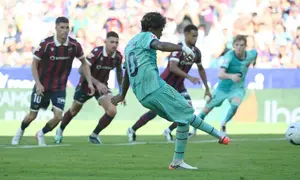 Penyerang Barcelona asal Spanyol bernomor punggung 10, Lamine Yamal, mencetak gol ketiga timnya melalui titik penalti dalam pertandingan Liga Spanyol antara Levante UD dan FC Barcelona di Stadion Ciutat de Valencia, Valencia, pada 13 September 2026. (JOSE JORDAN/AFP)