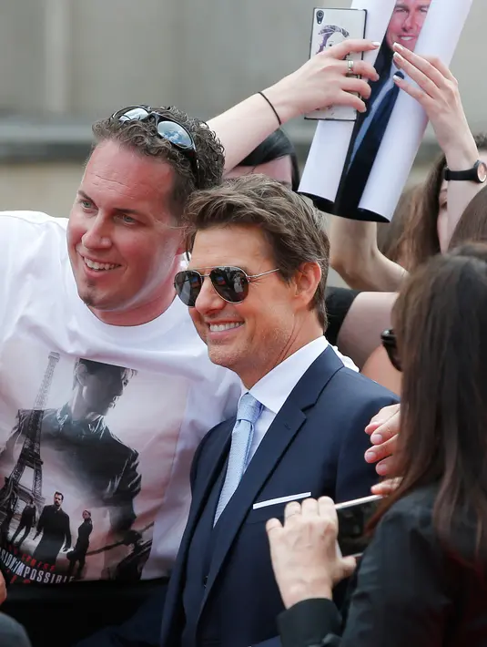 Aktor ganteng, Tom Cruise berfoto dengan penggemar setibanya di World premiere film Mission: Impossible Fallout di Paris, Kamis (12/7). Mission: Impossible 6 tersebut merupakan sekuel salah satu film yang paling dinantikan tahun ini. (AP/Thibault Camus)