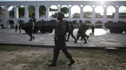 Sejumlah tentara patroli di lingkungan Lapa di Rio de Janeiro, Brasil, (30/7). Ribuan tentara mulai berpatroli di Rio de Janeiro di tengah lonjakan kekerasan di kota terbesar kedua di Brasil. (AP Photo / Leo Correa)