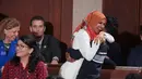 Senator Amerika Serikat (AS) Ilhan Omar merangkul putra sulungnya usai mengikuti pelantikan di Gedung Kongres AS, Capitol, Washington, Kamis (3/1). Omar mengenakan hijab saat pelantikan dirinya sebagai Anggota Senat AS. (Glen Stubbe/Star Tribune via AP)