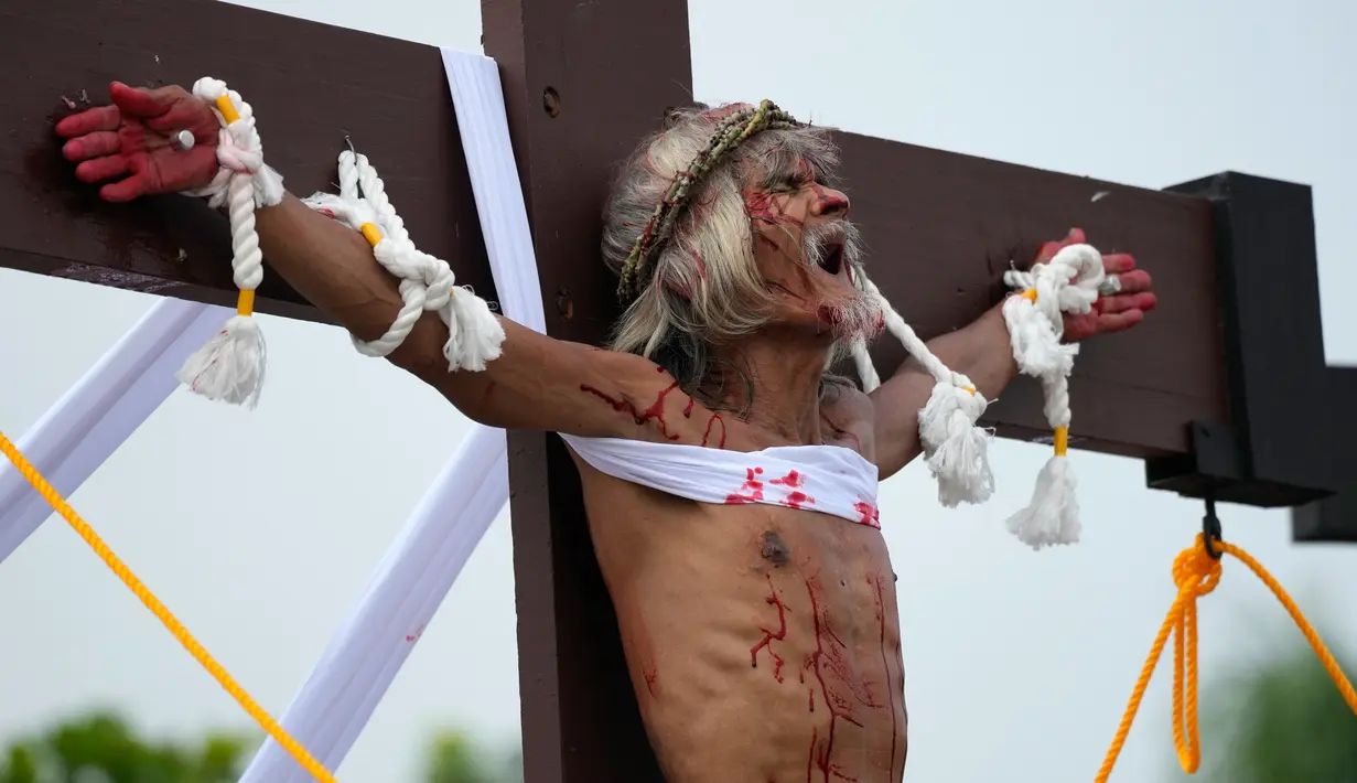 Wilfredo Salvador meringis setelah dia dipaku pada kayu salib saat memperagakan kembali penderitaan Yesus Kristus sebagai bagian dari ritual Jumat Agung di Desa San Pedro, Cutud, Provinsi Pampanga, Filipina, Jumat (7/4/2023). Penyaliban di kehidupan nyata, tradisi Jumat Agung berdarah yang ditolak oleh gereja Katolik, dilanjutkan di desa pertanian ini setelah jeda tiga tahun karena pandemi virus corona COVID-19. (AP Photo/Aaron Favila)