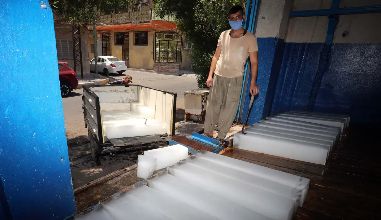 Seorang pria bekerja di sebuah pabrik pembuatan es di Baghdad, Irak, pada 5 Juli 2020. Seiring kenaikan suhu yang mendekati 50 derajat Celsius di Baghdad, bisnis pembuatan es di kota tersebut berkembang pesat dengan meningkatnya permintaan balok es. (Xinhua)