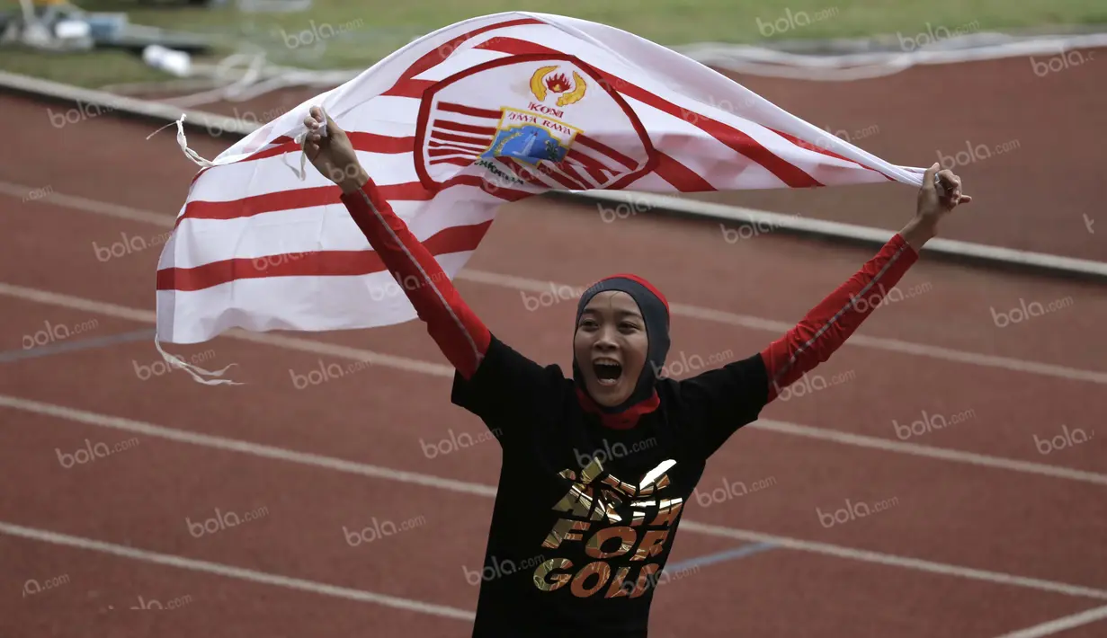 Ekspresi atlet DKI Jakarta, Nadia Anggraini, setelah memastikan meraih medali emas dalam final lompat tinggi putri PON XIX Jawa Barat 2016 di Stadion Pakansari, Bogor, Kamis (22/9/2016). (Bola.com/Arief Bagus)
