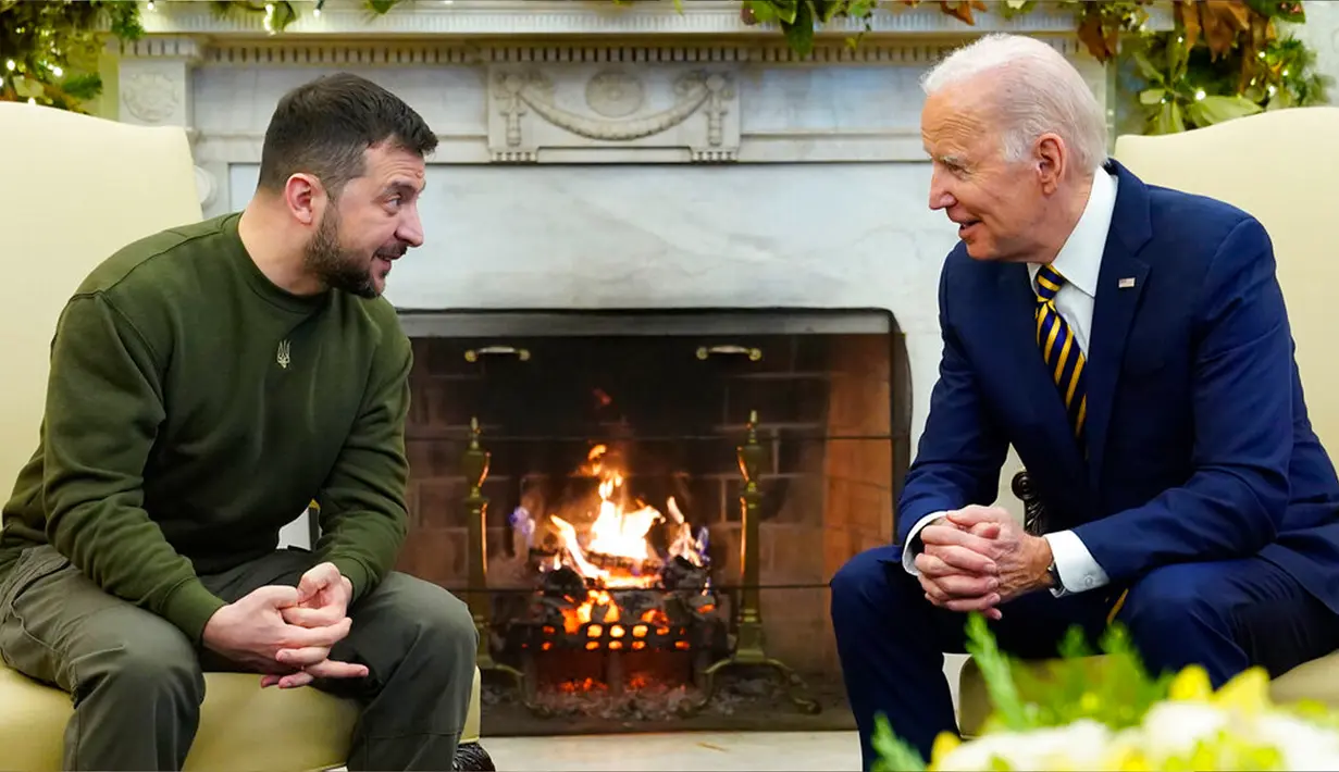 Presiden Amerika Serikat Joe Biden berbicara dengan Presiden Ukraina Volodymyr Zelenskyy saat mereka bertemu di Oval Office Gedung Putih, Washington, Amerika Serikat, 21 Desember 2022. Biden menuduh Rusia sengaja menggunakan musim dingin sebagai senjata. (AP Photo/Patrick Semansky)