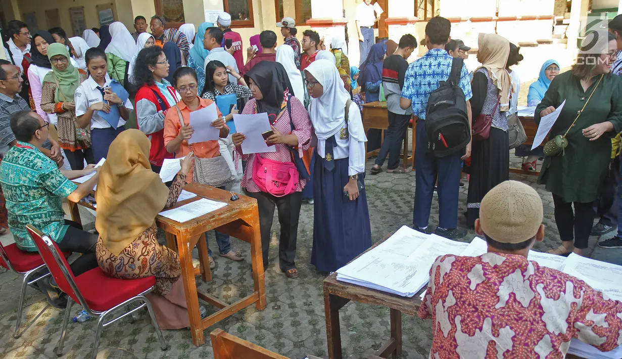 Suasana saat para siswa dengan orangtua murid akan mengikuti seleksi Penerimaan Peserta Didik Baru (PPDB) di SMAN 1 Depok, Kota Depok, Jawa Barat, Selasa (18/6/2019). Sistem PPDB Jawa Barat berlangsung pada tanggal 17-22 Juni 2019. (Liputan6.com/Herman Zakharia)