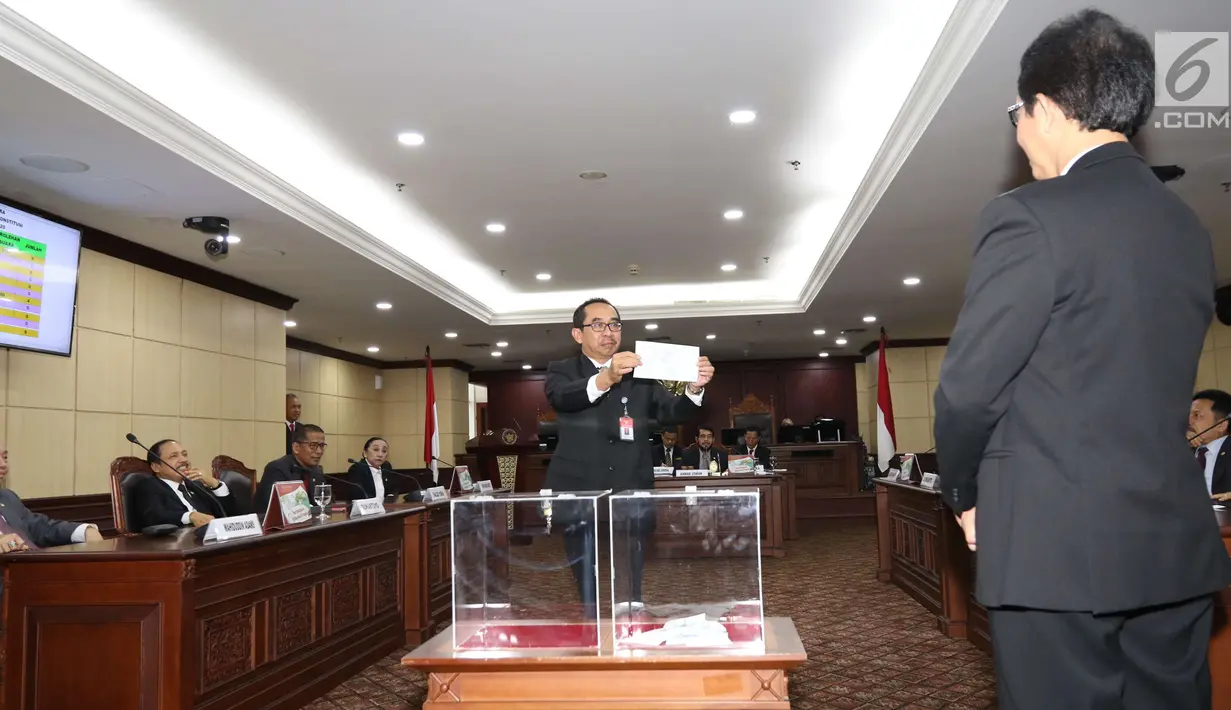 Hakim Konstitusi menunjukkan surat suara saat pemilihan Ketua Mahkamah Konstitusi (MK) di Jakarta, Senin (2/3). Anwar Usman terpilih sebagai Ketua MK periode 2018-2020. (Liputan6.com/Angga Yuniar)