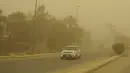 <p>Pengemudi memasang lampu kabut mobil mereka saat mereka mengemudi selama badai pasir Musim Semi melalui ibukota Irak, Baghdad (5/5/2022). Irak kembali diselimuti lapisan jingga tebal karena mengalami serangkaian badai debu terbaru yang semakin sering terjadi. (AFP/Sabah Arar)</p>