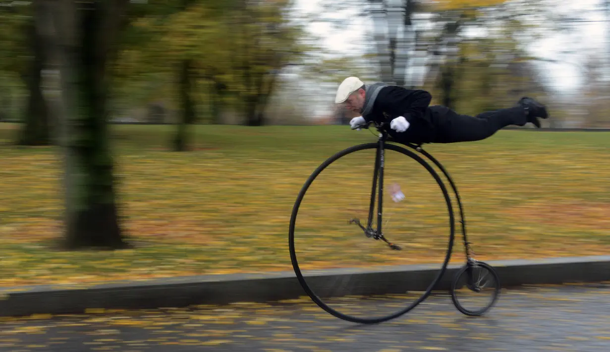 Seorang penggemar sepeda mengenakan kostum sejarah sambil mengendarai Penny Farthing atau dikenal sebagai sepeda roda tinggi selama kompetisi tradisonal 'One Mile Race' di Praha, Republik Ceko pada 3 November 2018. (Photo by Michal CIZEK / AFP)