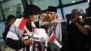 Duta Besar Palestina untuk Indonesia, Abdalfatah A. K. Alsattari (tengah), berbincang dengan salah satu aktivis yang tergabung dalam misi Global Sumud Flotilla 2.0 yang tiba di pintu kedatangan Terminal 3 Bandara Internasional Soekarno-Hatta pada Minggu (24/5/2026) sore. (Kapanlagi.com/Budy Santoso)