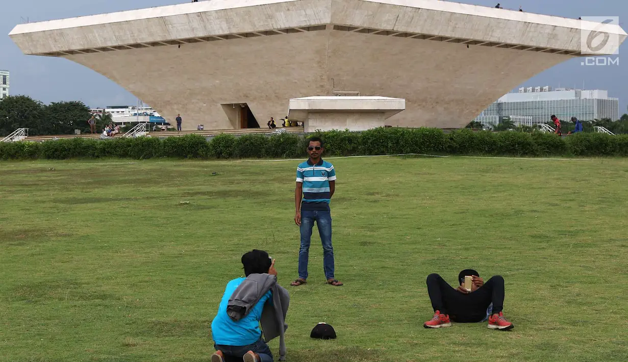 Wistawan berfoto di kawasan Monumen Nasional (Monas), Jakarta, Sabtu (19/5). Kawasan wisata yang menjadi simbol ibukota tersebut menjadi salah satu lokasi warga untuk “ngabuburit” atau menunggu waktu berbuka puasa. (Liputan6.com/Immanuel Antonius)