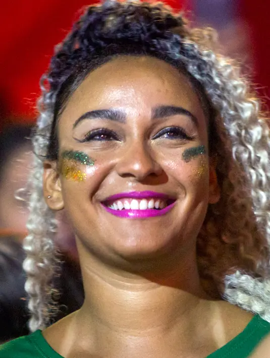Fans wanita tersenyum sebelum pertandingan antara Brasil melawan Argentina pada semifinal Copa America 2019 di Praça Maua, Rio de Janeiro (2/7/2019). Di pertandingan ini Brasil menang 2-0 atas Argentina berkat gol striker Gabriel Jesus dan Roberto Firmino. (AFP Photo/Daniel Ramalho)
