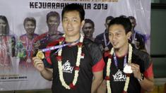 Pasangan ganda putra Indonesia, Mohammad Ahsan/Hendra Setiawan, menunjukan mendali saat konfrensi pers di Bandara Soekarno-Hatta, Tangerang, Selasa (27/8). Ahsan/Hendra meraih gelar pada Kejuaraan Dunia Bulutangkis 2019. (Bola.com/Yoppy Renato)