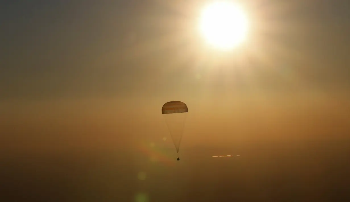 Kapsul pesawat luar angkasa Soyuz TMA-20M menggunakan parasut melakukan pendaratan di dekat Kota Zhezkazgan, Kazakhstan, (7/9). Selama 172 hari tiga astronaut ini berada di ISS. (Bill Ingalls/NASA/Reuters)