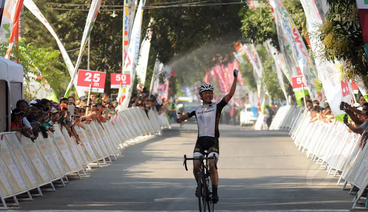 Kyosuke Takei mengangkat tangan saat melintasi garis finis etape I balap sepeda International Tour de Banyuwangi Ijen, (16/10/2014). (Liputan6.com/Helmi Fithriansyah)