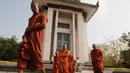 Biksu meninggalkan stupa yang berisi ratusan tengkorak dan tulang korban rezim Khmer Merah usai berdoa di Choeung Ek memorial, Kamboja (17/4). Mereka berdoa untuk memperingati 42 tahun jatuhnya rezim Khmer Merah pimpinan Pol Pot. (AP Photo/Heng Sinith)