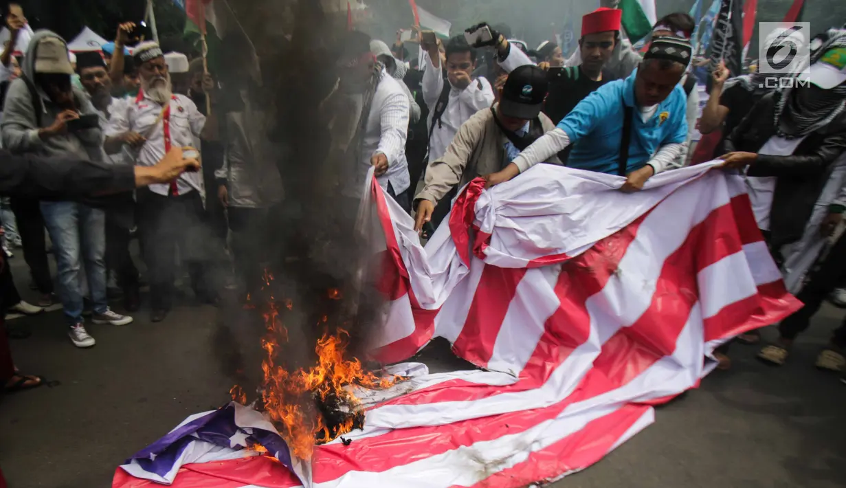 Massa aksi bela Palestina membakar bendera Amerika Serikat (AS) saat berunjuk rasa di depan Kedubes AS, Jakarta, Senin (11/12). Massa memprotes kebijakan Presiden Donald Trump yang mengakui Yerusalem sebagai Ibu Kota Israel. (Liputan6.com/Faizal Fanani)