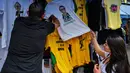 Pembeli memilih kaus bergambar Calon Presiden Brasil, Jair Bolsonaro dari sayap kanan dijajakan di sebuah toko pinggir jalan yang populer di Sao Paulo, 8 Oktober 2018. September lalu, Bolsonaro dirawat setelah ditusuk ketika kampanye. (AFP/NELSON ALMEIDA)