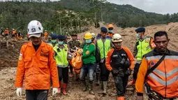 Penemuan ini menambah total korban jiwa menjadi tiga orang. Tampak dalam foto, petugas penyelamat membawa kantong jenazah dari puing-puing rumah yang hancur di lokasi longsor di Desa Situkung, Banjarnegara, Jawa Tengah, pada Rabu 19 November 2025. (DEVI RAHMAN/AFP)